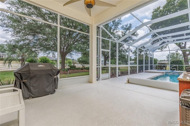 sunroom featuring ceiling fan and a pool