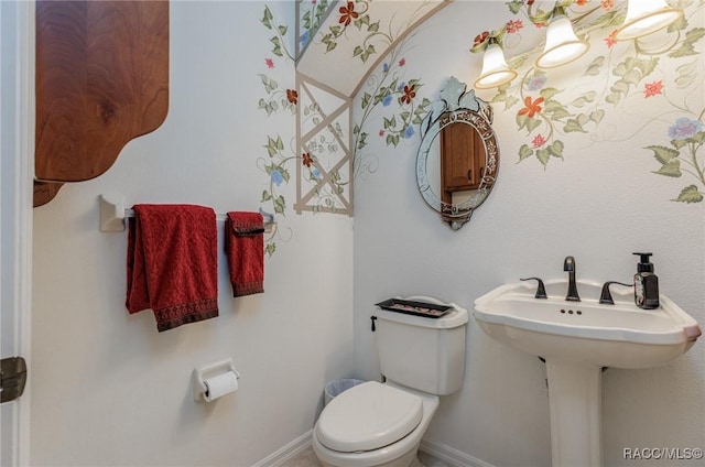half bathroom featuring toilet and baseboards