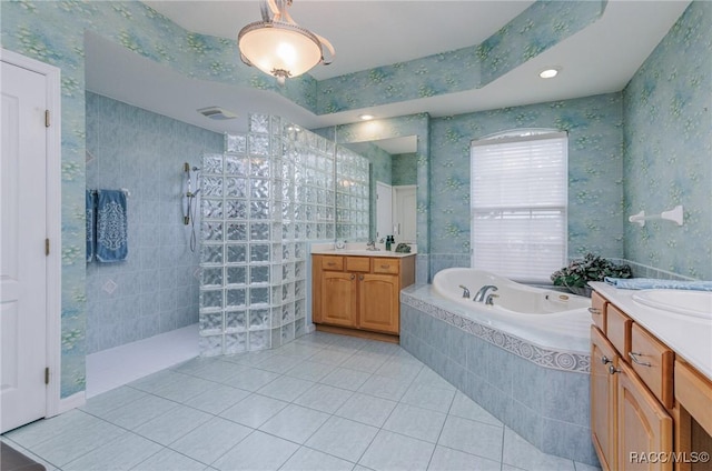 full bathroom featuring wallpapered walls, a bath, a walk in shower, tile patterned flooring, and two vanities