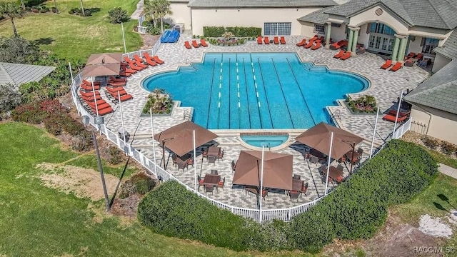 community pool with a yard, fence, and a patio