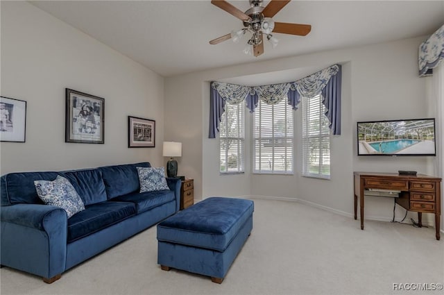 carpeted living room with baseboards and a ceiling fan