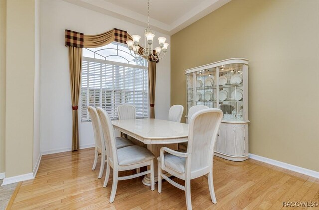 dining area with an inviting chandelier, light wood-type flooring, and baseboards