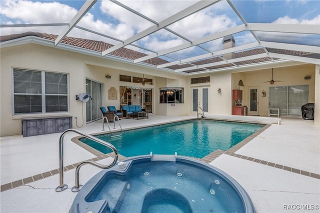 view of swimming pool with a patio, french doors, a ceiling fan, a pool with connected hot tub, and an outdoor living space