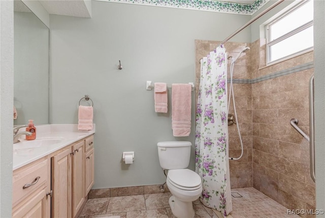 full bath with toilet, tiled shower, vanity, and tile patterned flooring