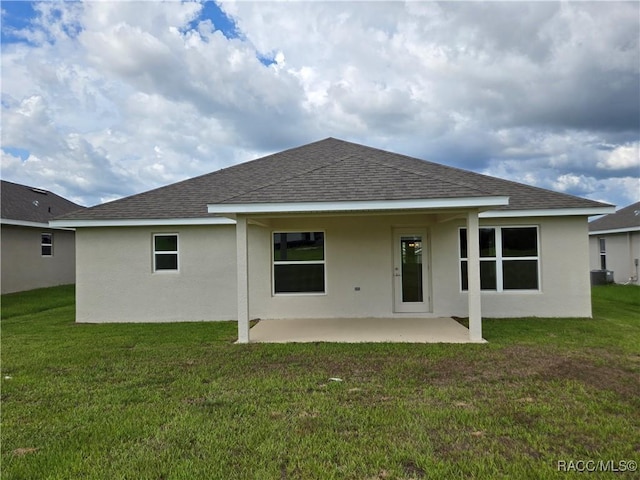 348 W Rexford Dr, Beverly Hills, FL 34465 - back of house with roof with shingles, stucco siding, a patio area, and a lawn