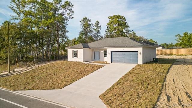 single story home with a front lawn, stucco siding, driveway, an attached garage, and fence