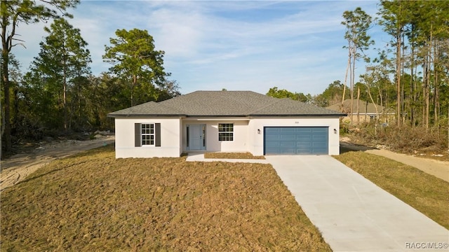 view of front of home with stucco siding, a garage, driveway, roof with shingles, and a front yard