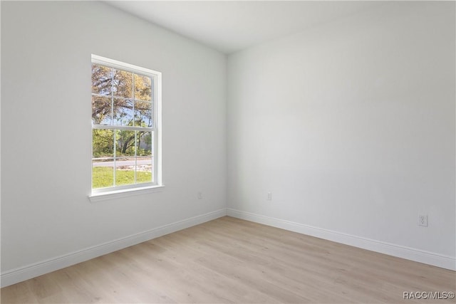 spare room with light wood finished floors and baseboards