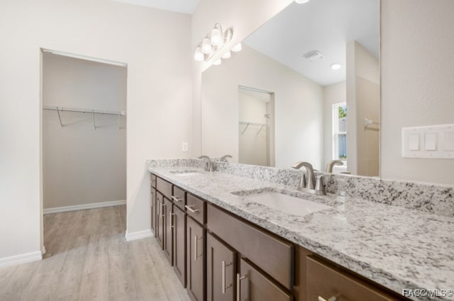 bathroom featuring hardwood / wood-style flooring, vanity, and vaulted ceiling