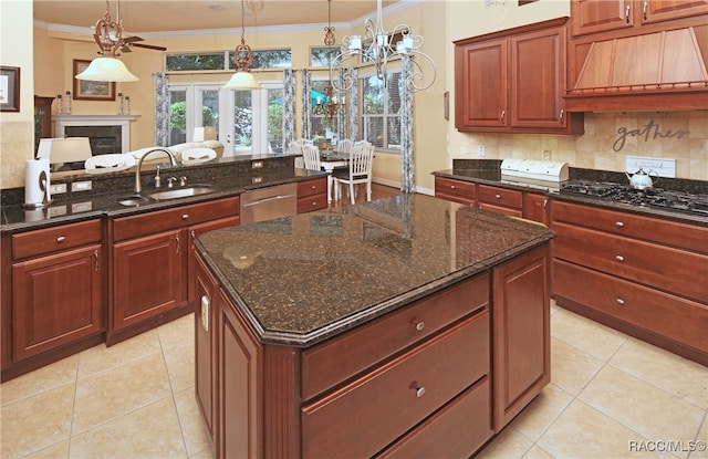 kitchen featuring pendant lighting, a center island, sink, and dark stone counters