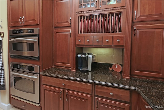 kitchen featuring backsplash and dark stone countertops