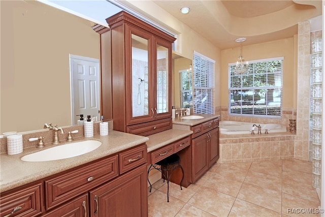 bathroom featuring tiled bath, tile patterned flooring, vanity, and an inviting chandelier