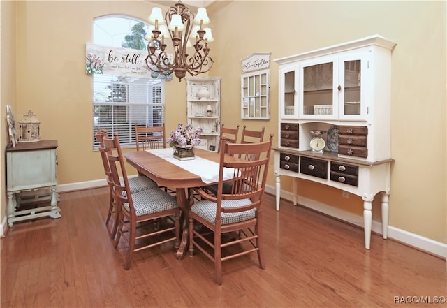 dining area with hardwood / wood-style floors and a notable chandelier