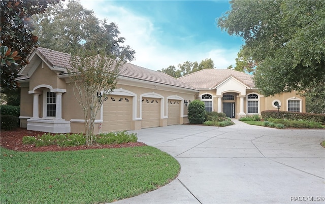 ranch-style home featuring a front lawn and a garage