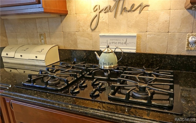 details featuring dark stone countertops, black gas cooktop, and decorative backsplash