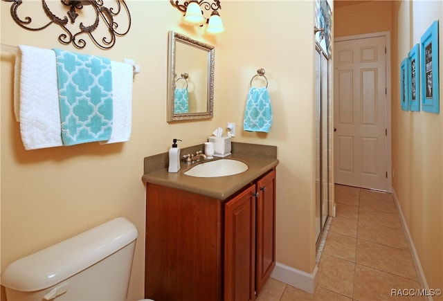 bathroom featuring tile patterned flooring, vanity, and toilet