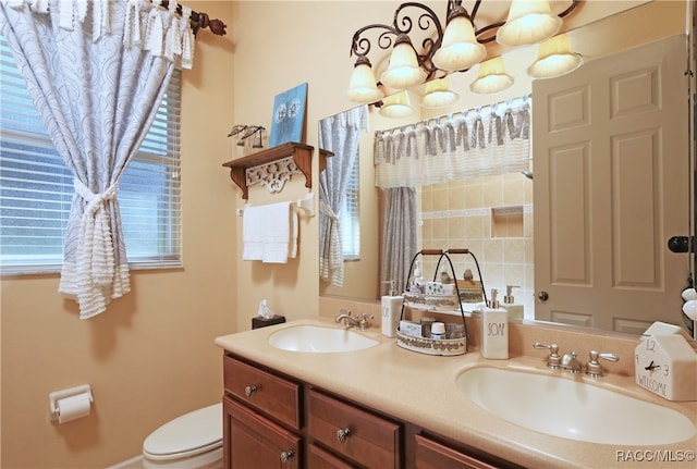 bathroom featuring vanity, a notable chandelier, and toilet