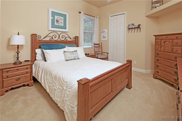 bedroom featuring light colored carpet and a closet