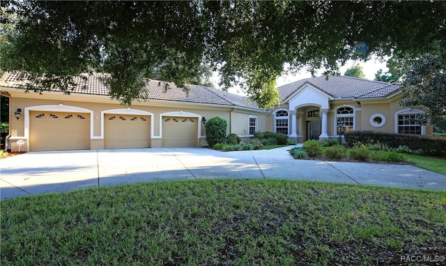 view of front of property featuring a front lawn and a garage