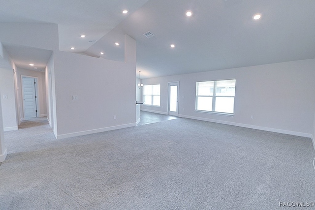 unfurnished room featuring light carpet, high vaulted ceiling, and a chandelier