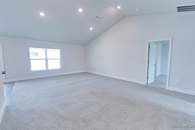 carpeted empty room featuring lofted ceiling