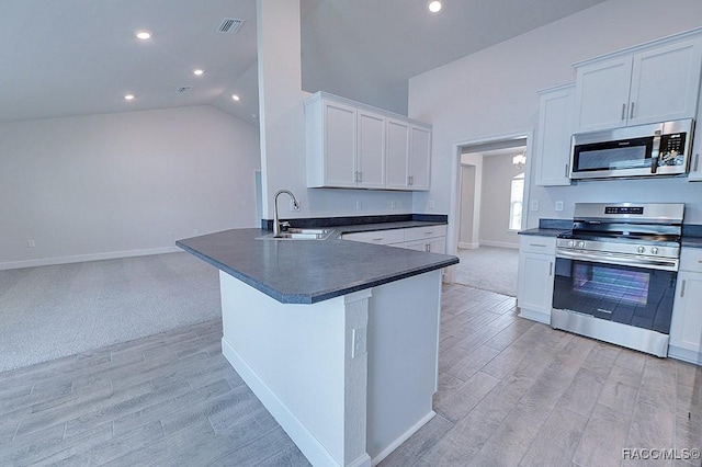 8330 N India Way, Citrus Springs, FL 34434 - kitchen featuring stainless steel appliances, dark countertops, a sink, light wood-style floors, and white cabinets