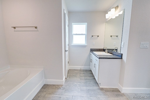 bathroom featuring a washtub, hardwood / wood-style floors, and vanity