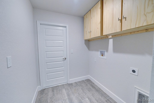 clothes washing area with cabinets, hookup for a washing machine, light hardwood / wood-style floors, and electric dryer hookup