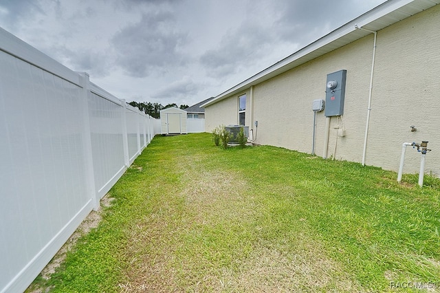 view of yard featuring a shed and central air condition unit