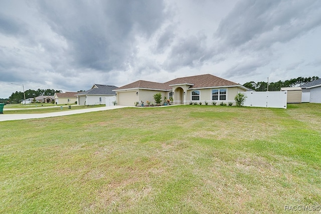 view of front of home with a front yard and a garage