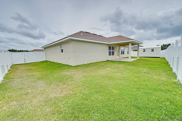 rear view of property with a lawn and a patio