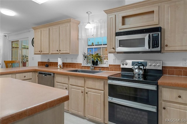 kitchen featuring light brown cabinetry, appliances with stainless steel finishes, pendant lighting, and sink