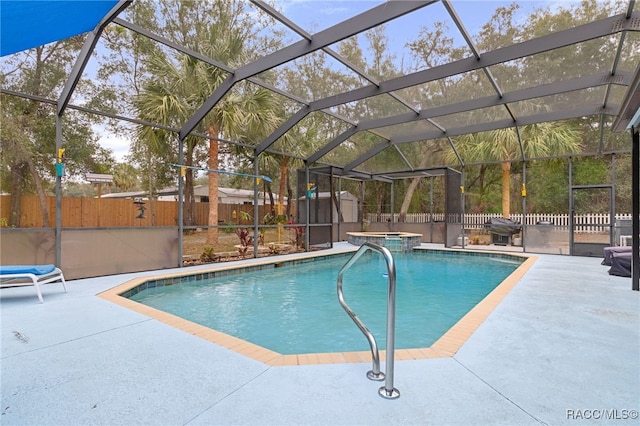 view of pool featuring a patio, glass enclosure, and a storage shed