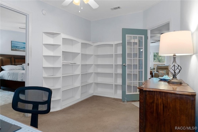 walk in closet with french doors, ceiling fan, and light colored carpet