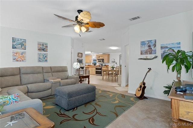 living room with ceiling fan and light colored carpet