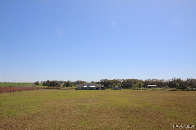 view of yard featuring a rural view and fence