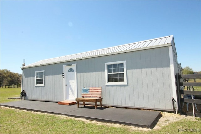 view of outbuilding featuring an outdoor structure and fence