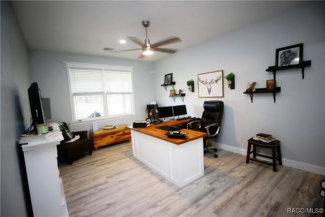 home office with visible vents, a ceiling fan, light wood-style floors, and baseboards