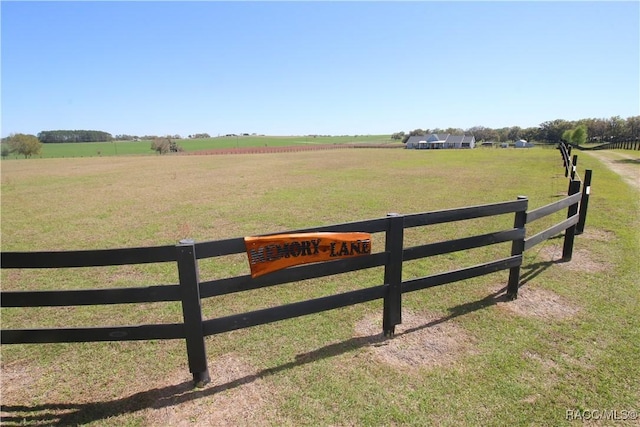 view of yard with a rural view and fence