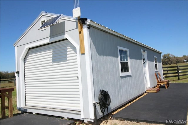 view of home's exterior with an outbuilding and fence