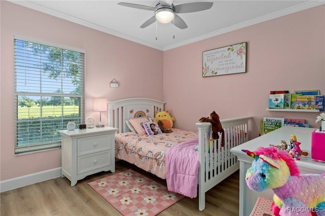 bedroom featuring crown molding, light hardwood / wood-style floors, and ceiling fan