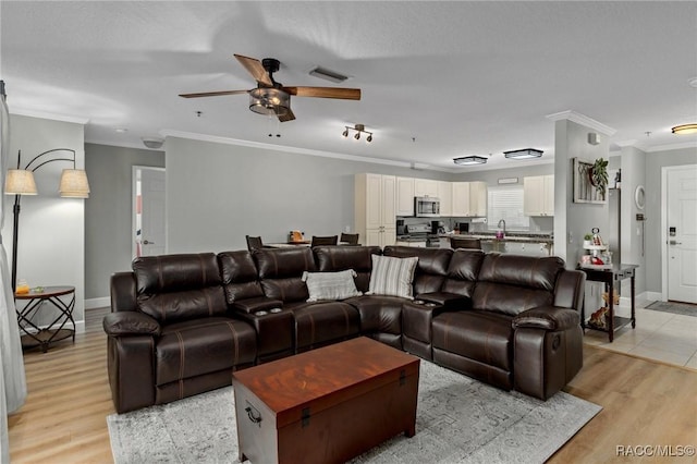 living room with ornamental molding, sink, ceiling fan, and light hardwood / wood-style floors