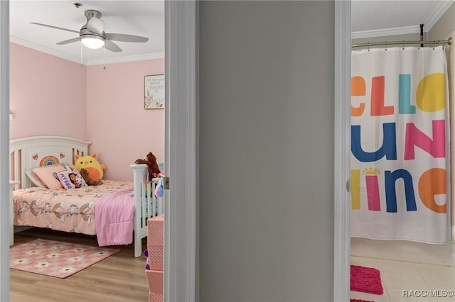 bedroom featuring crown molding, ceiling fan, and light hardwood / wood-style flooring