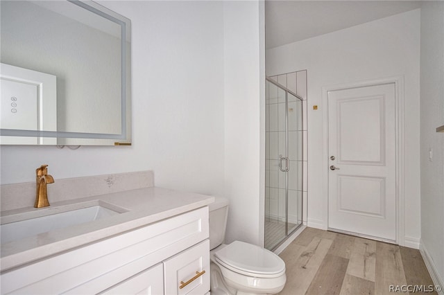 bathroom with toilet, vanity, wood-type flooring, and walk in shower