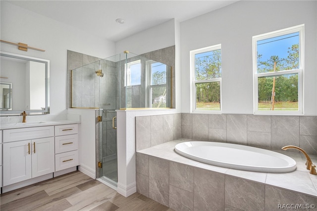 bathroom featuring shower with separate bathtub, vanity, and hardwood / wood-style flooring