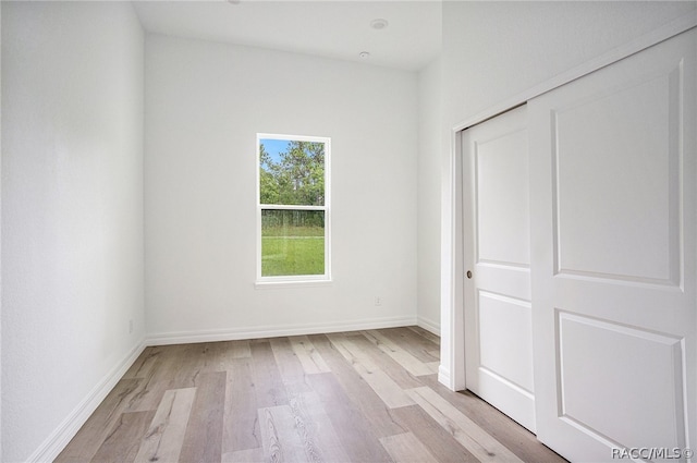 unfurnished bedroom featuring light wood-type flooring and a closet