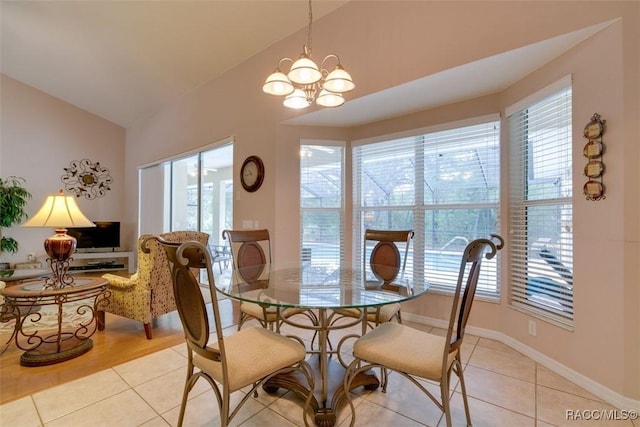 dining space featuring a wealth of natural light, vaulted ceiling, and light tile patterned floors