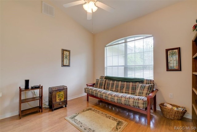 living area featuring lofted ceiling, ceiling fan, and light wood-type flooring