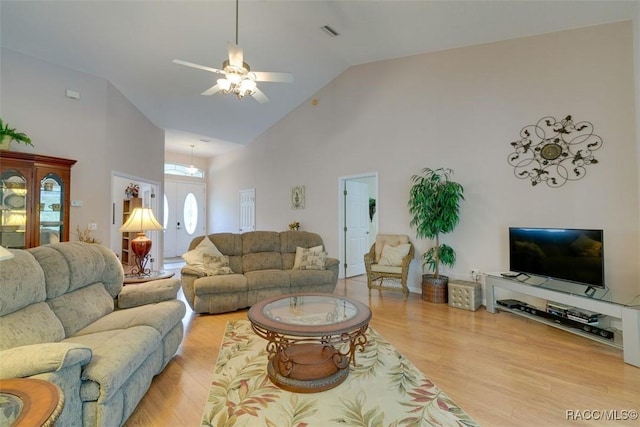 living room featuring ceiling fan, light wood-type flooring, and high vaulted ceiling