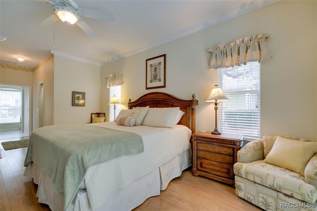 bedroom featuring multiple windows, ornamental molding, ceiling fan, and light hardwood / wood-style flooring